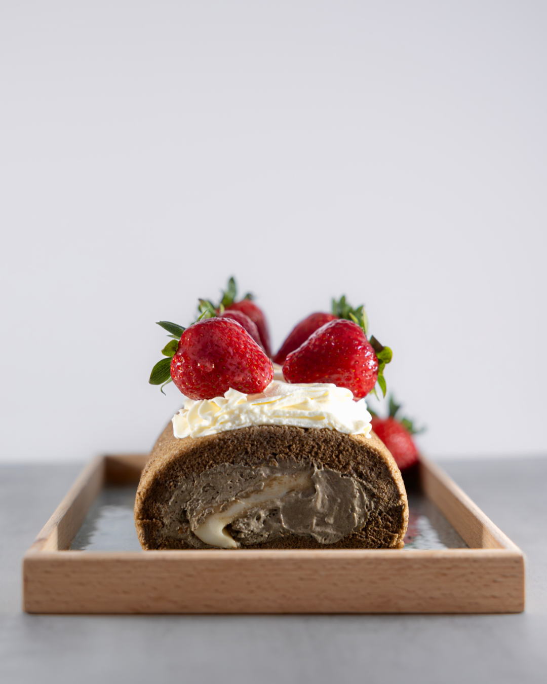Taiwanese Tieguanyin Tea roll cake with moch, velvety tieguanyin cream, rich salted cheese foam and fresh strawberries. Crafted by Okaeri Bakery in London